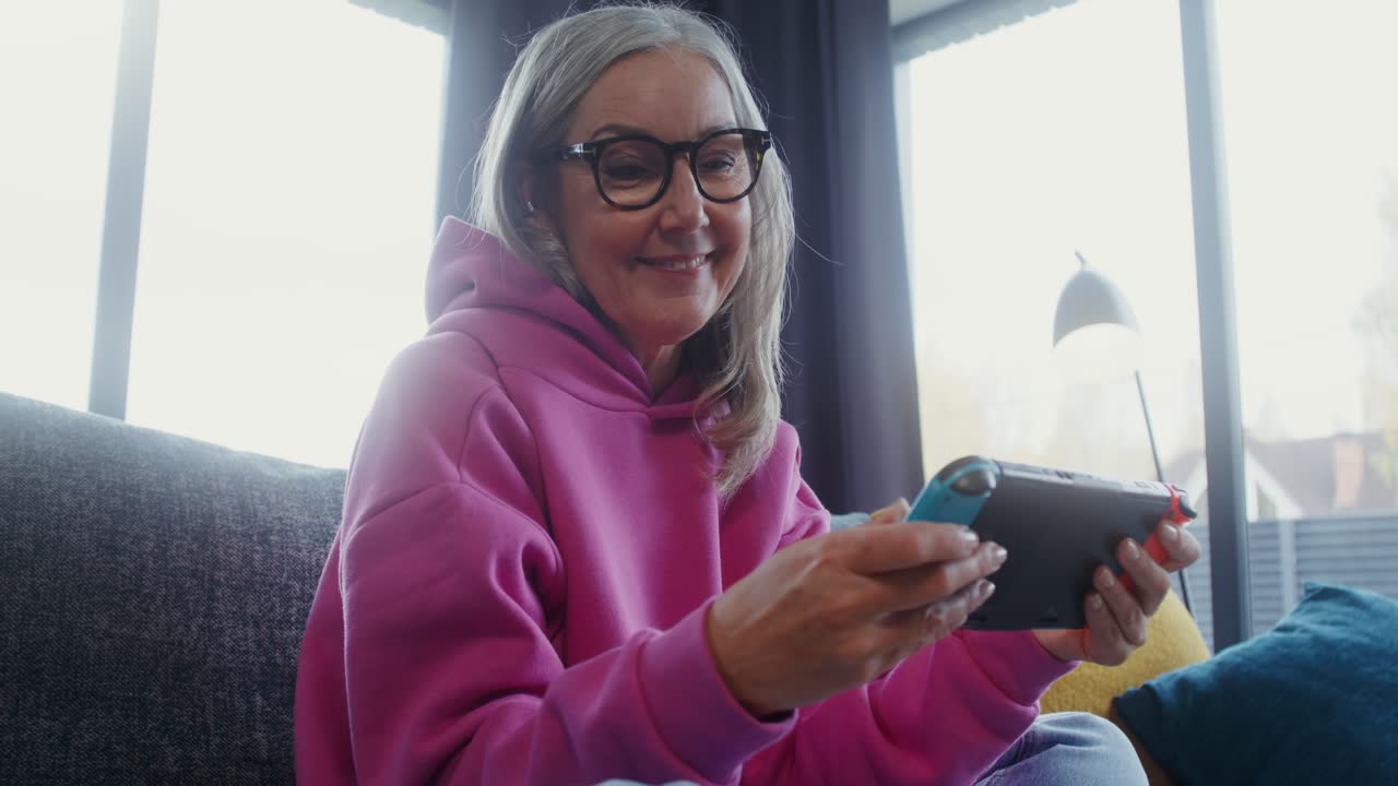 Mature woman playing Nintendo Switch on couch