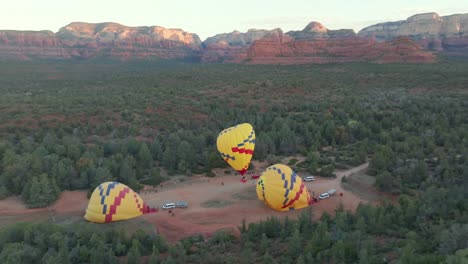 hot air balloons being inflated for flight in sedona, arizona - aerial drone shot