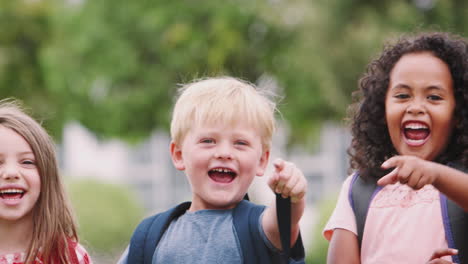 portrait of excited elementary school pupils on playing field at break time