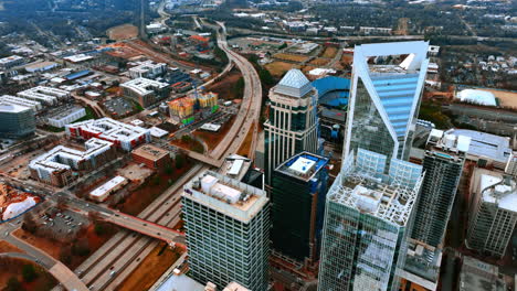 wide multi-lane highway with bridges above dividing the city. drone footage high above the skyscrapers of charlotte, north carolina, usa