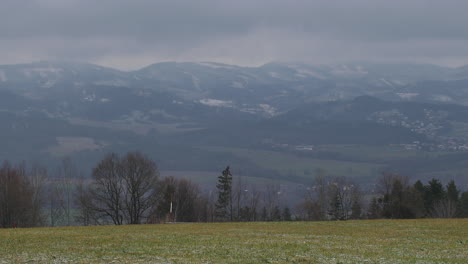View-of-fields-and-city-in-the-background-on-which-fresh-snow-is-falling-in-slow-motion