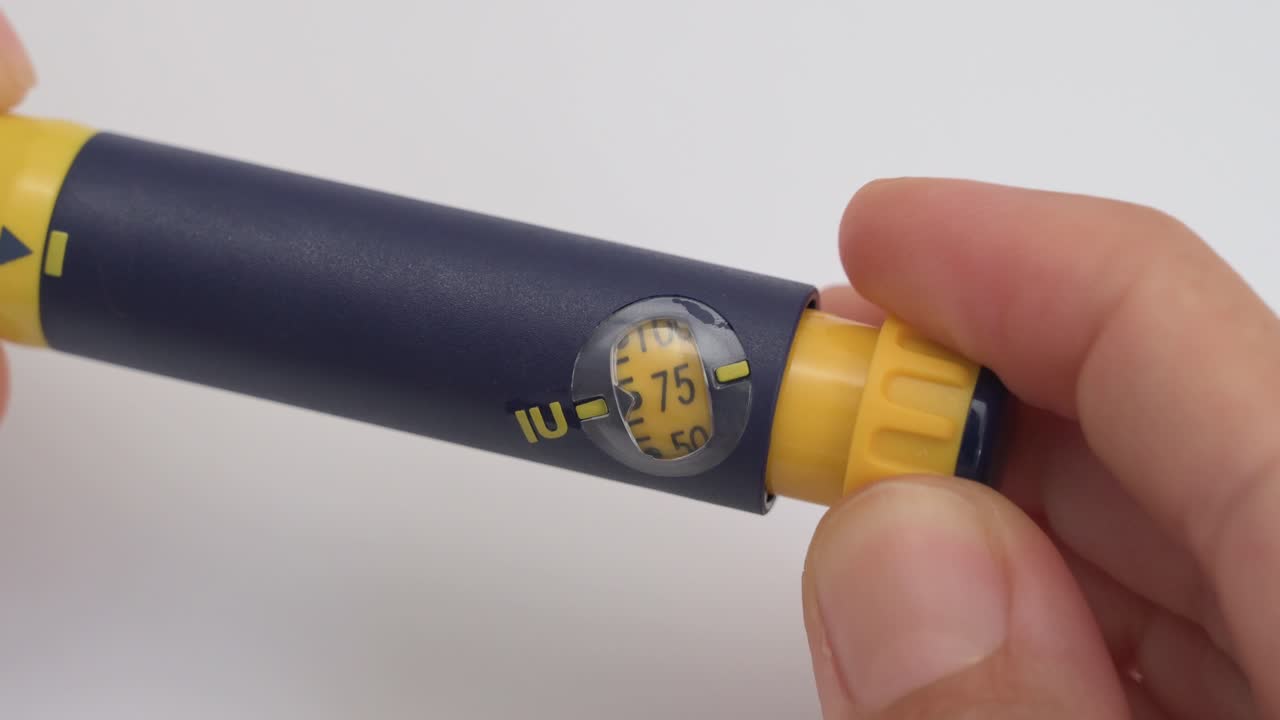 Person is adjusting the dosage dial on a follicle stimulating hormone injection pen