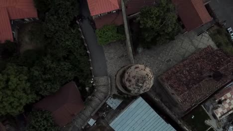 una toma de un dron bajando para hacer zoom sobre las flores que crecen en la parte superior de la iglesia en signagi