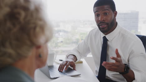 senior woman meeting with male financial advisor in office