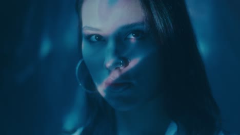 close-up portrait of a woman with blue neon lighting