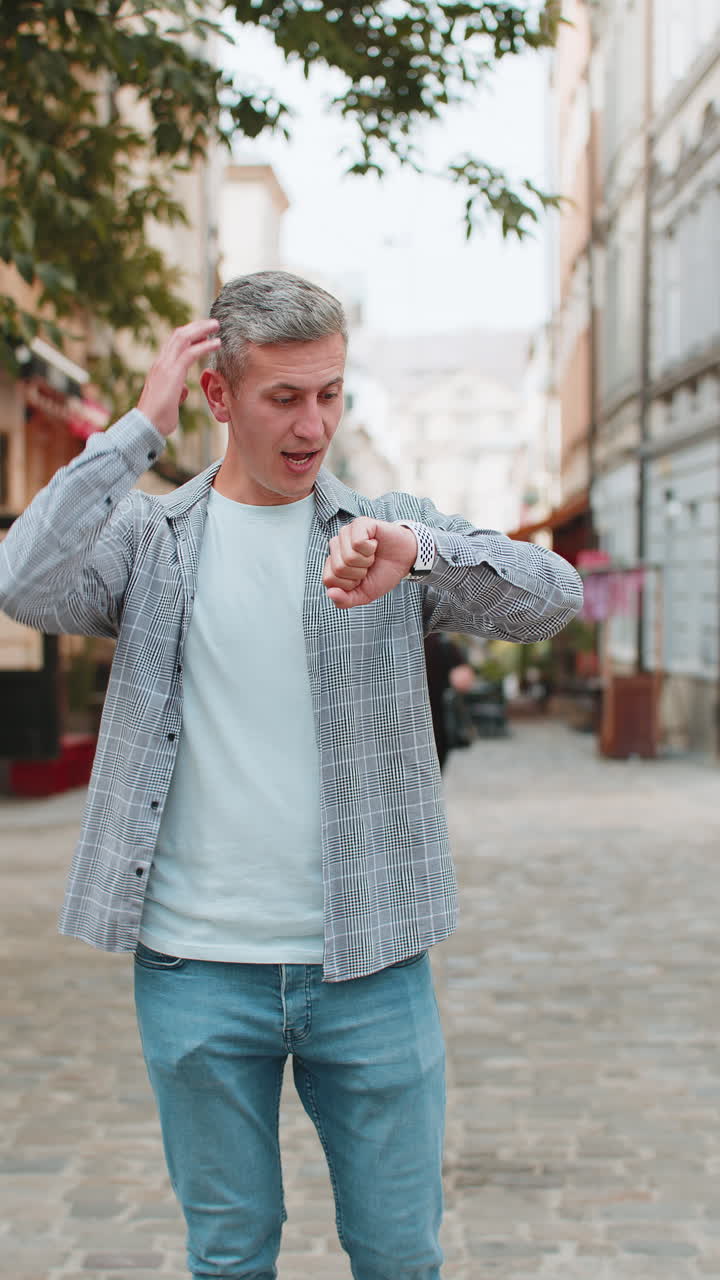 Mature man worrying to be punctual with anxiety checking time on watch running late to transport