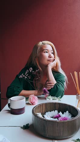 woman in contemplation with floral arrangement