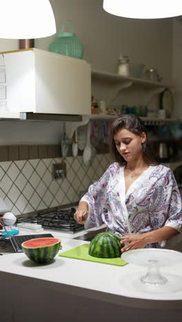mujer cortando una sandía en la cocina