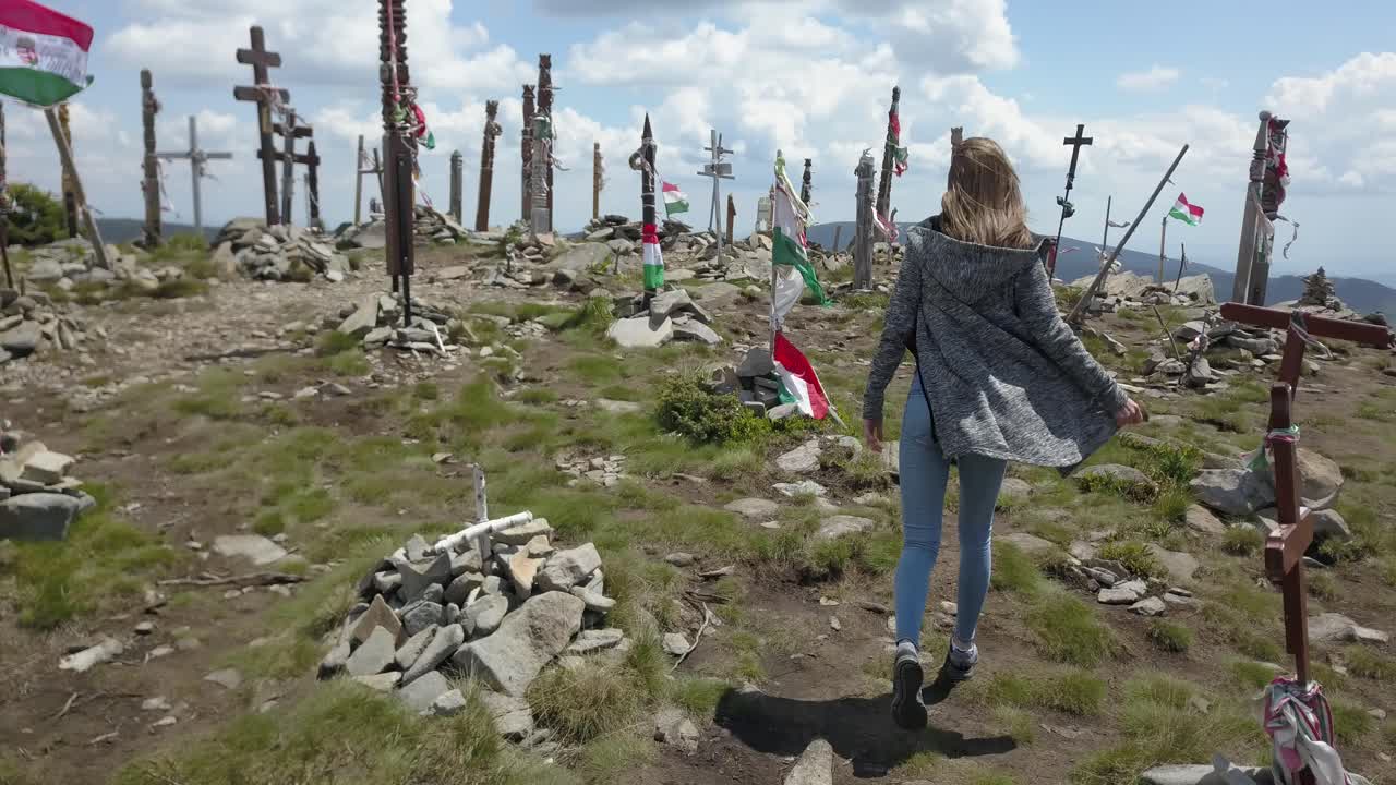 la cámara sigue a una chica caminando por una montaña.