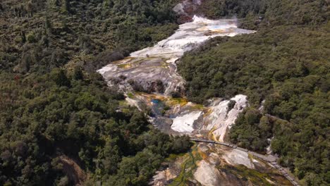 Aerial-overview-of-silica-terraces,-hot-and-mud-pools-in-vibrant-colourful-volcanic-park