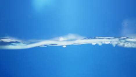 macro shot of water droplets creating intricate patterns, reflecting light for a shiny and creative look at the beauty of liquid motion