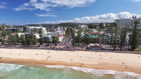tourists at the sandy shoreline of manly beach on the northern beaches of sydney, australia. aerial shot