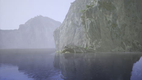 misty landscape with rocky cliffs and calm water reflecting natural beauty