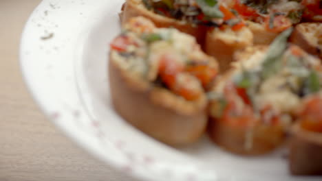 plate of toasted bread with tomato, cheese, bay leaf and olive oil, close-up