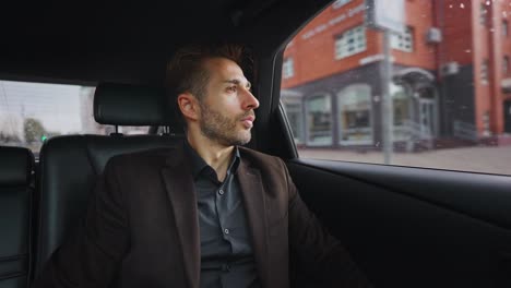 Businessman looking out of a car window