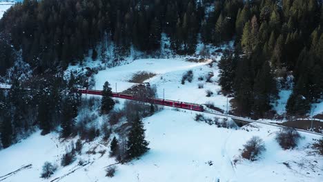 Excelente-Vista-Aérea-De-Un-Tren-Que-Viaja-A-Través-De-Una-Montaña-Nevada-En-Suiza