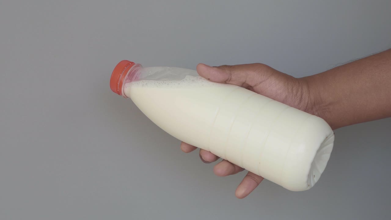 persona que sostiene una botella de leche