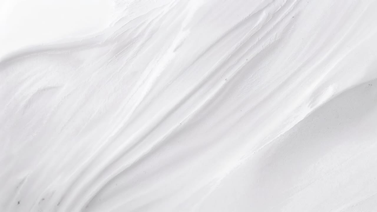 Tecido branco drapeado em movimento, exibindo dobras relaxando em close-up, com sombras suaves e manchas