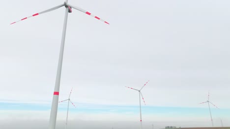 giant wind turbines rotating above green fields