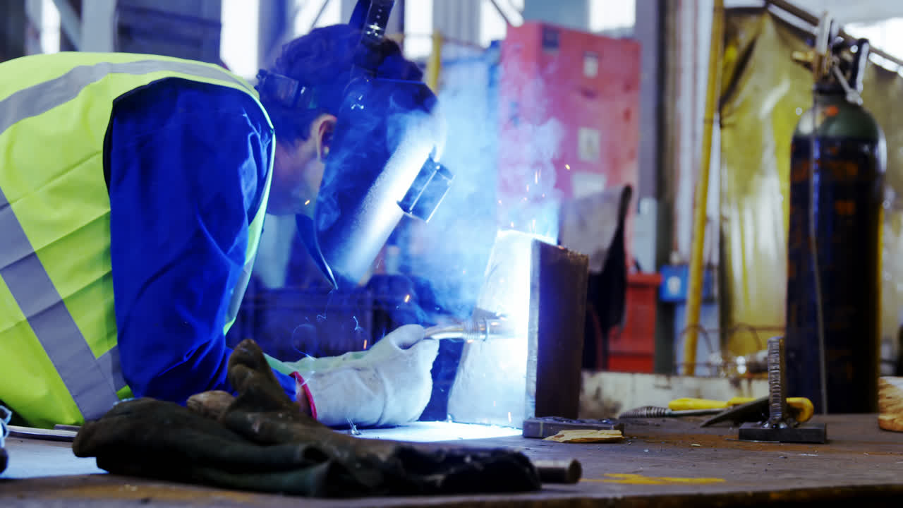 Male engineer using welding torch 4k
