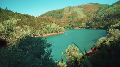 Río-De-Campo-Con-Barco-Pasando-Entre-Verdes-Colinas-De-Montaña-En-Verano-Al-Sol-Bajo-El-Cielo-Azul-4k