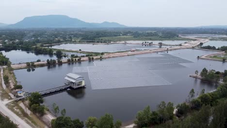 Vista-Aérea-De-Un-Enorme-Panel-Solar-Sobre-El-Agua-En-Una-Zona-Rural,-Granja-Solar-Flotante