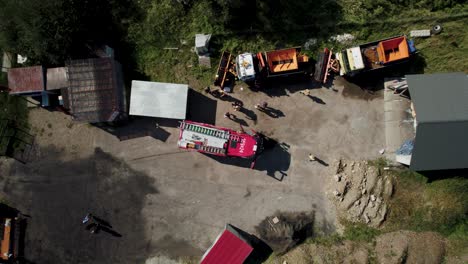 4k-Aerial-Shot-of-Firefighters-Jumping-Out-of-Firetruck-in-Sunny-Day