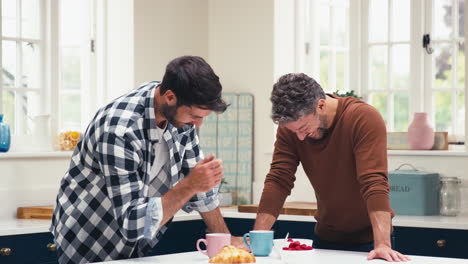 pareja de hombres del mismo sexo en casa en la cocina desayunando juntos