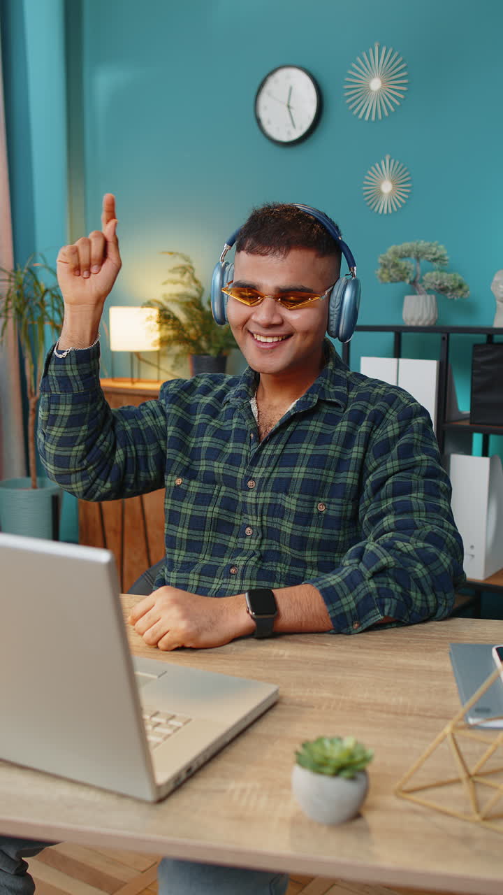 Hombre de negocios escuchando música a través de auriculares inalámbricos relajándose tomando un descanso portátil en la mesa
