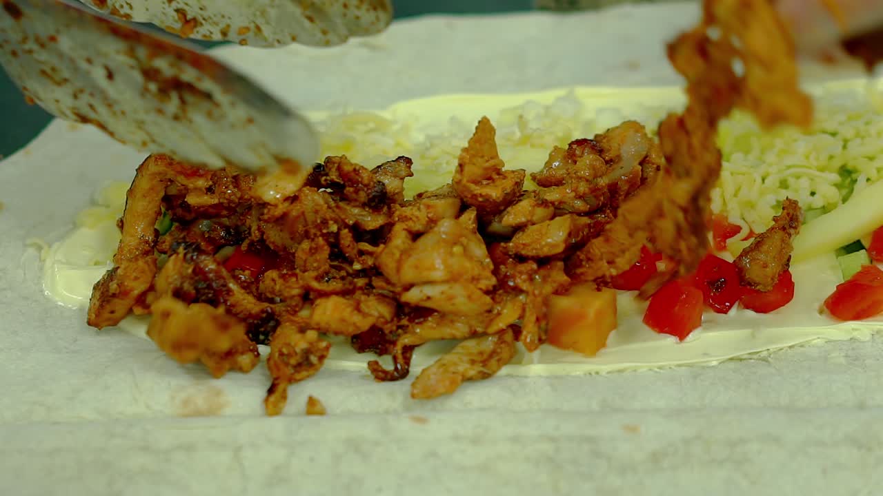 cu cocinero a cámara lenta prepara el wok agrega un pollo asado delicioso a las verduras frescas y el queso