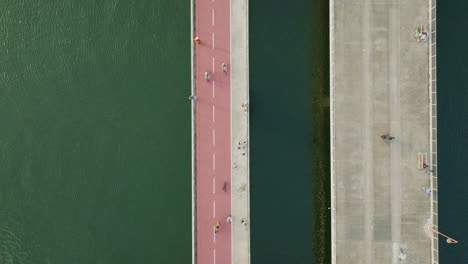 stunning drone shot following bicycles on a bridge over a river