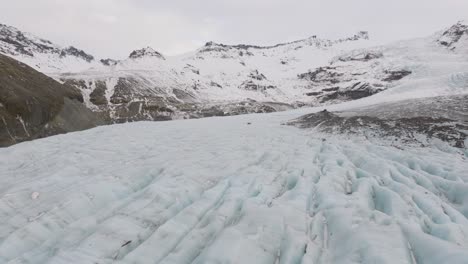 aerial panoramic landscape view over ice cracks and formations in virkisjokull glacier covered in snow, iceland