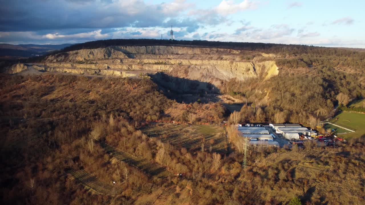 Mining quarry with a transmission tower at the top of the hill