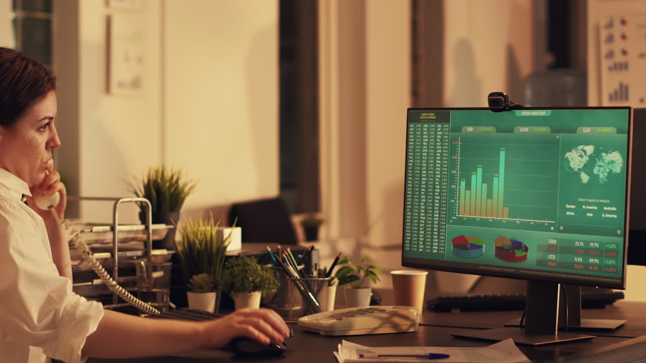Female employee looking at financial diagrams on monitor