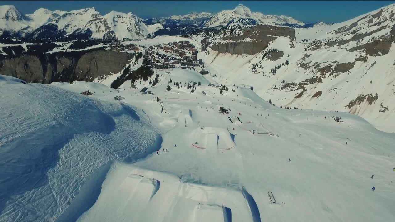 Una ripresa aerea di uno snowboarder che atterra un grande salto nello snowpark ad Avoriaz in Francia