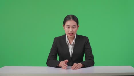 live news studio with professional asian female anchor reporting on the events of the day on the green screen