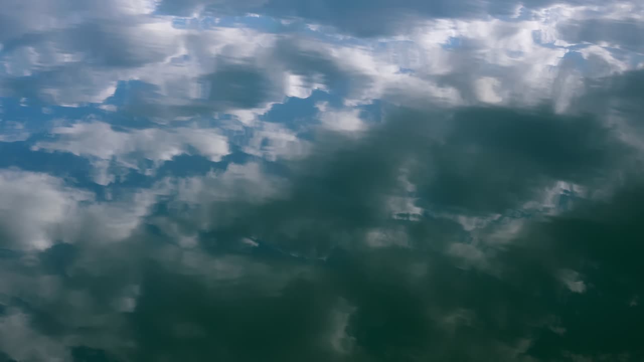 Clouds mirroring on the calm water during sunset