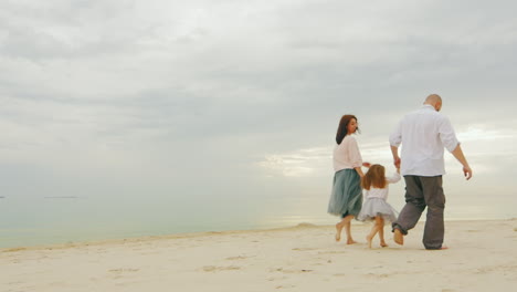 Happy-Family-Together-Walking-Along-Shore-Of-Calm-Sea