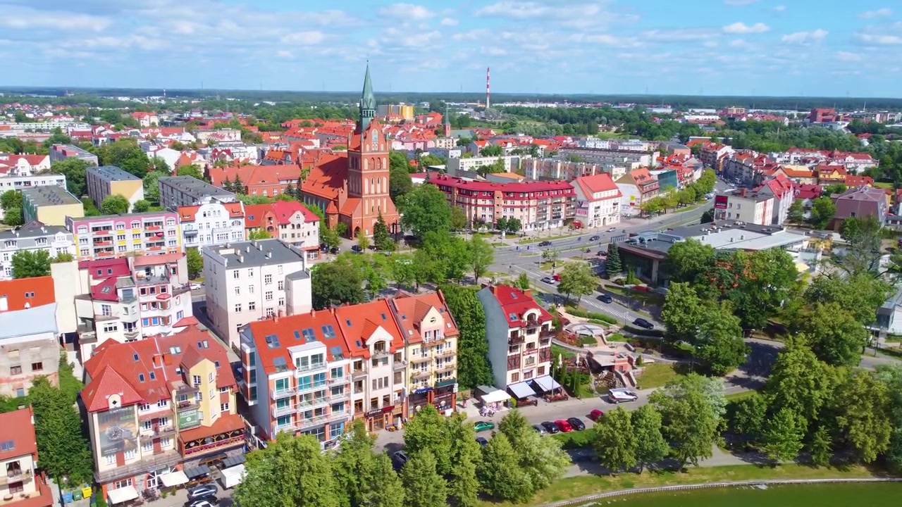 Widok z lotu ptaka na urocze polskie miasteczko z zabytkowymi budynkami i bujną zielenią.