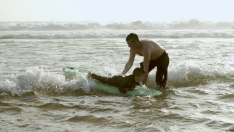 father helping son swimming on board