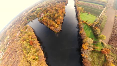 AERIAL-forest-in-amazing-autumn-shades-with-road-hiding-under-treetops