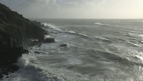 cinematic dawn shot of waves hitting the coast in cornwall, england