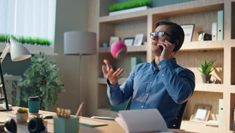 talking businessman calling smartphone playing office. happy man speaking phone