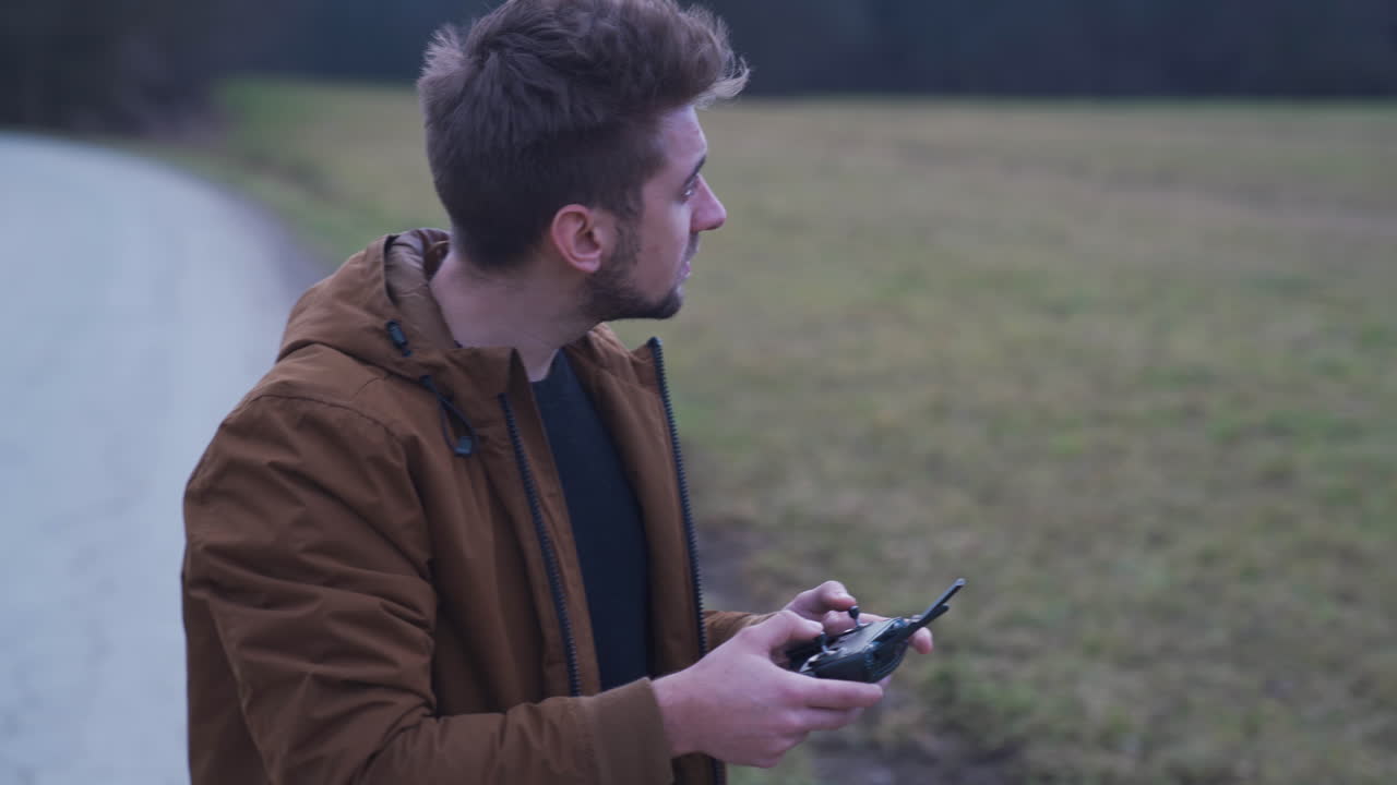 Giovane uomo che pilota un drone all'aperto
