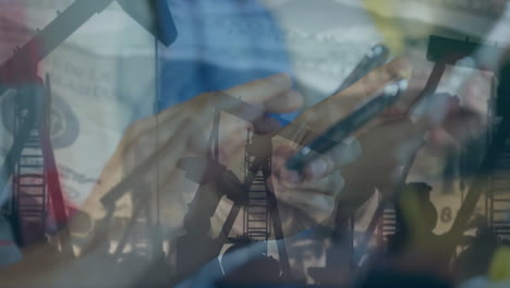 Using smartphone, person analyzing energy market with animation of oil pumps silhouetted