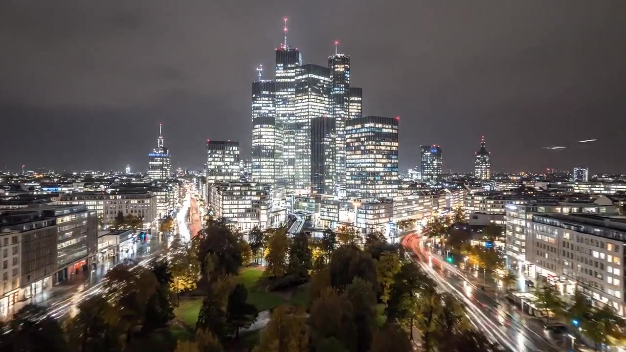 Paesaggio Urbano Notturno: Una Vista Spettacolare di Grattacieli Illuminati Sotto la Pioggia con Luci del Traffico Sfocate Che Creano un'Atmosfera da Metropoli Vibrante.