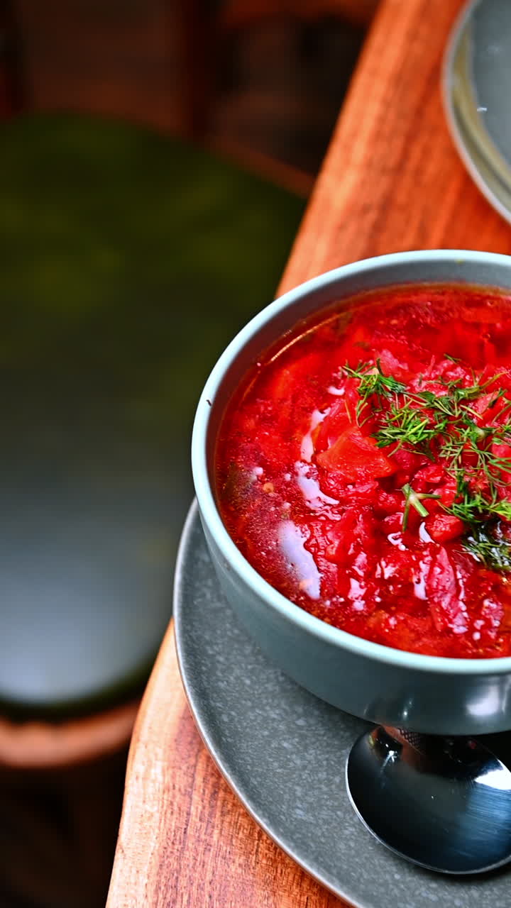 Thick red stew with herbs. Hearty red stew with visible vegetables and herbs served in a deep bowl