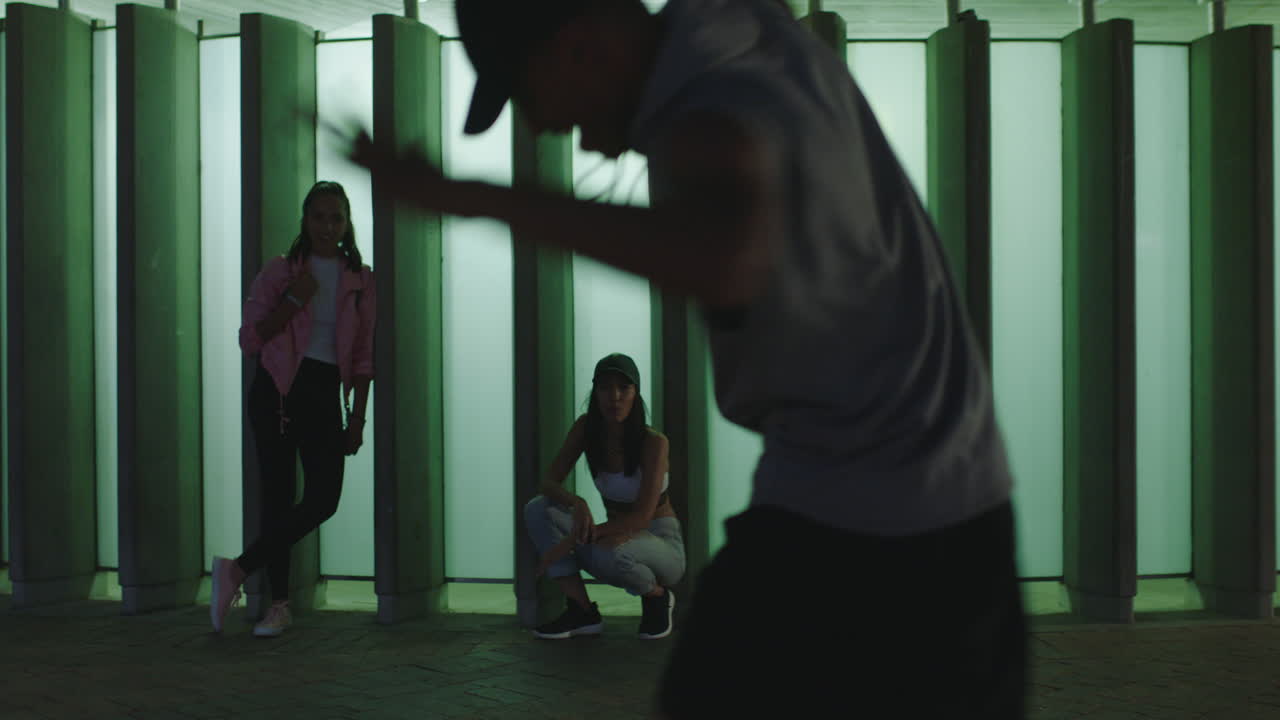 춤추는 남자 젊은 혼성 인종 거리 댄서 브레이크 댄스 프리스타일 동작 친구들이 시청하고 응원하며 밤에 도시에서 어울리는 것을 즐긴다