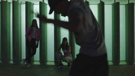 bailarín joven de raza mixta bailarín de calle breakdancing freestyle se mueve amigos viendo animar disfrutando pasar el rato en la ciudad por la noche