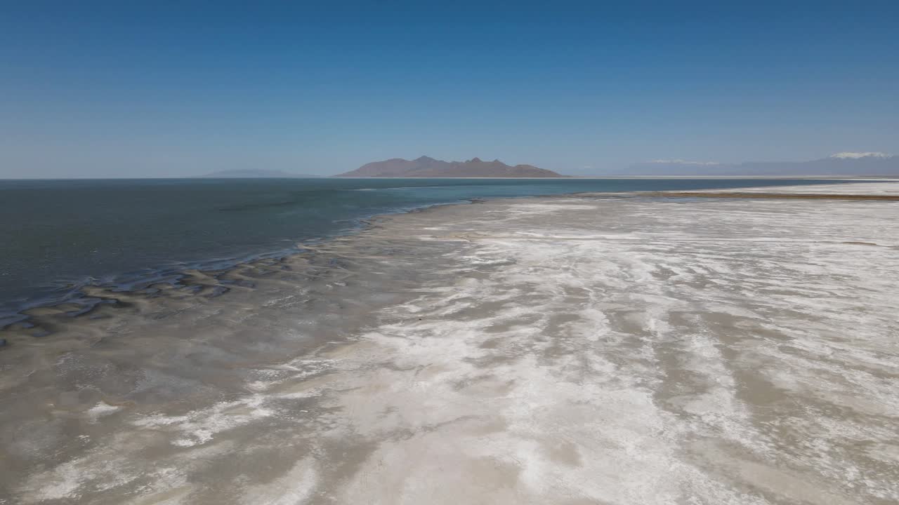 A 4K drone shot over the perfectly flat Bonneville Salt Flats, found west of the Great Salt Lake, in western Utah, with a shallow layer of standing water flooding the vast salt plain&rsquo;s surface